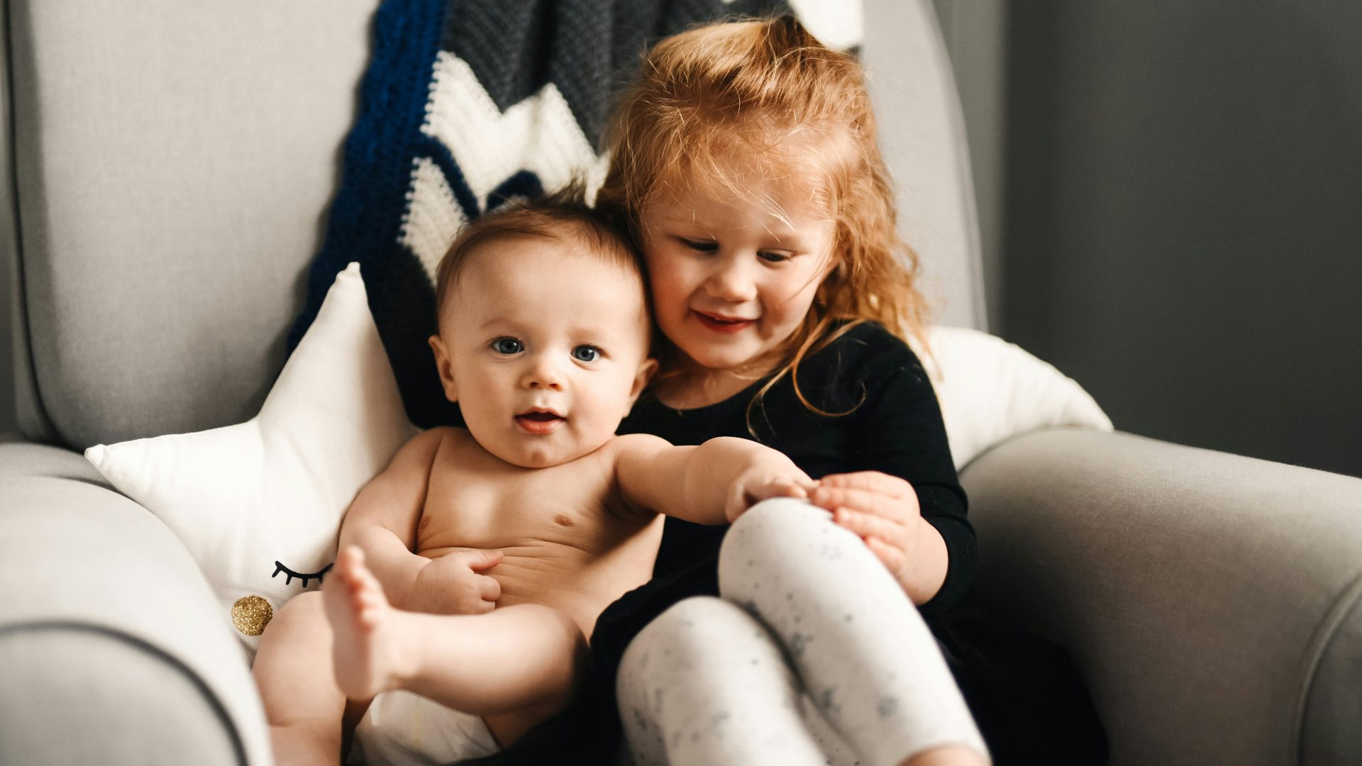 woman in black long sleeve shirt carrying baby in black onesie