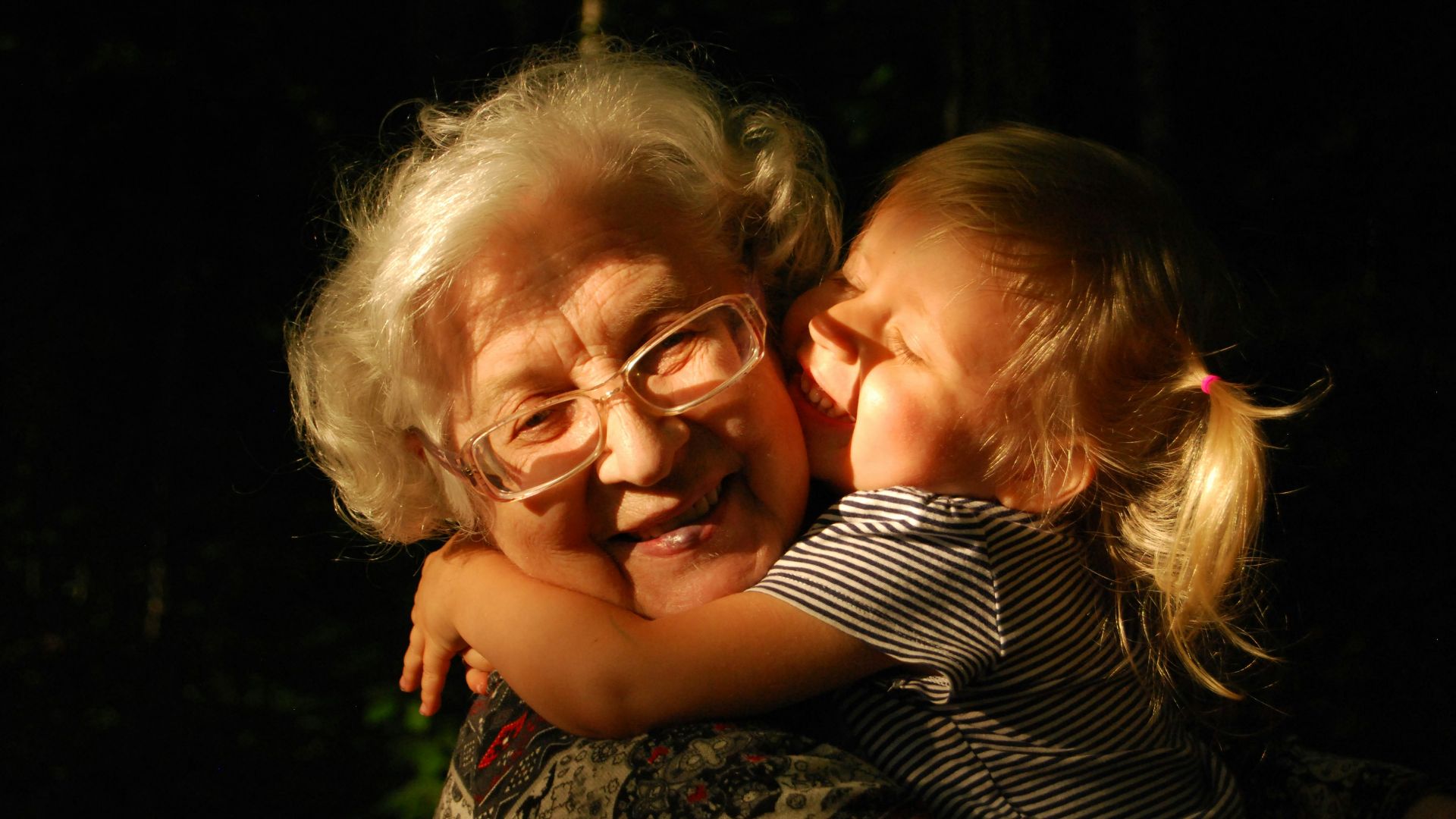 woman in black and white striped shirt hugging girl in black and white striped shirt