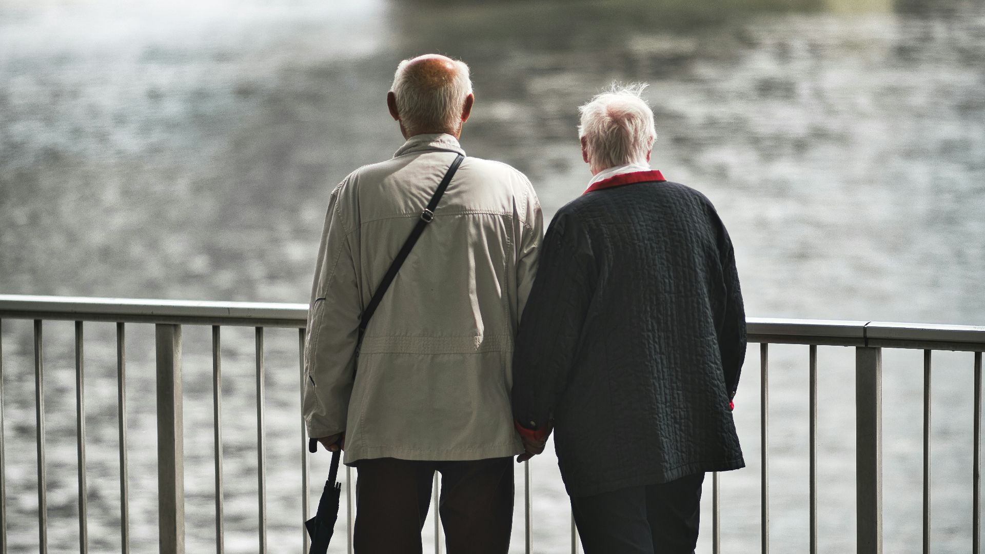 man in gray suit standing near body of water during daytime