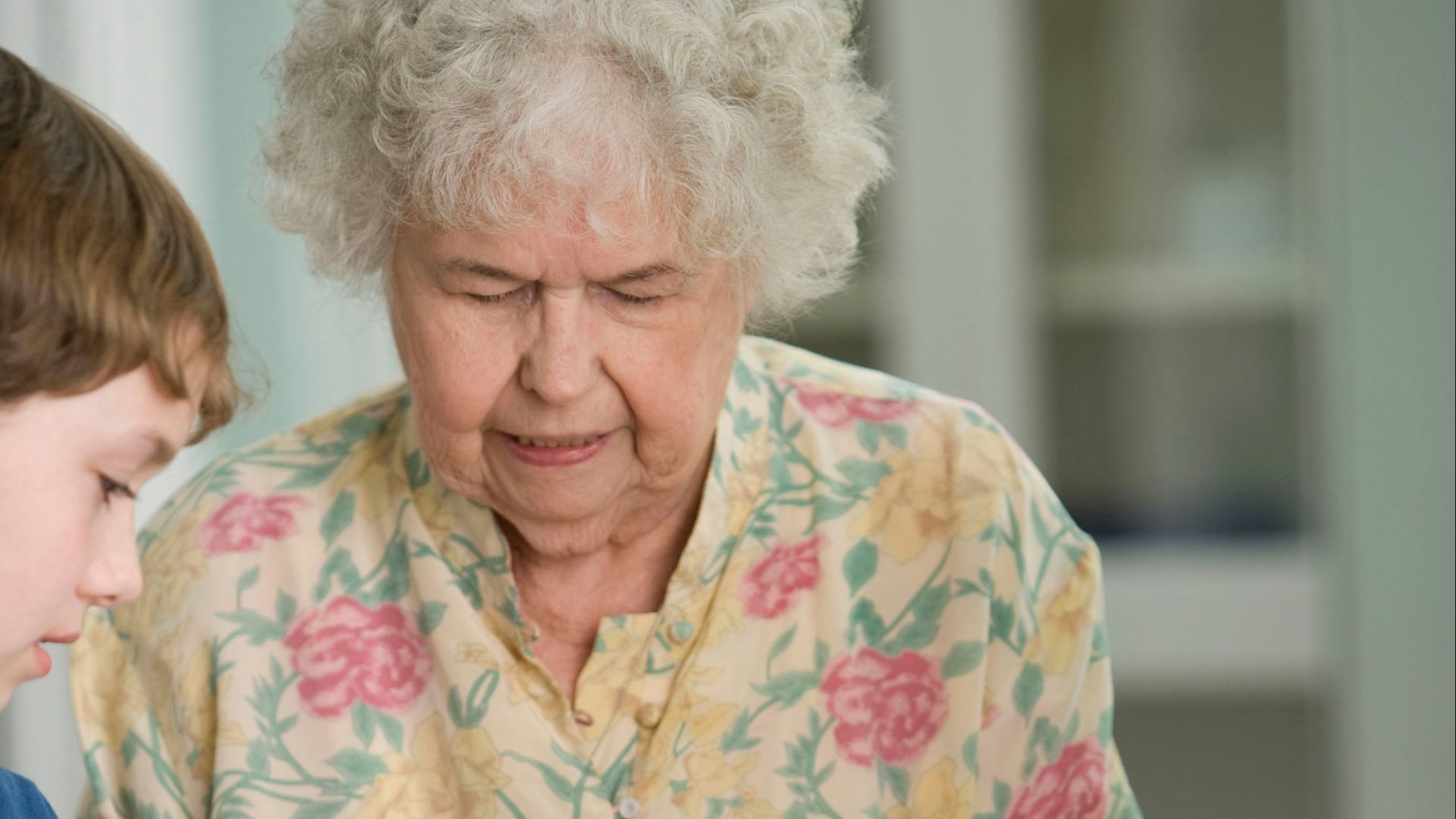 woman in yellow and white floral button up shirt holding yellow banana