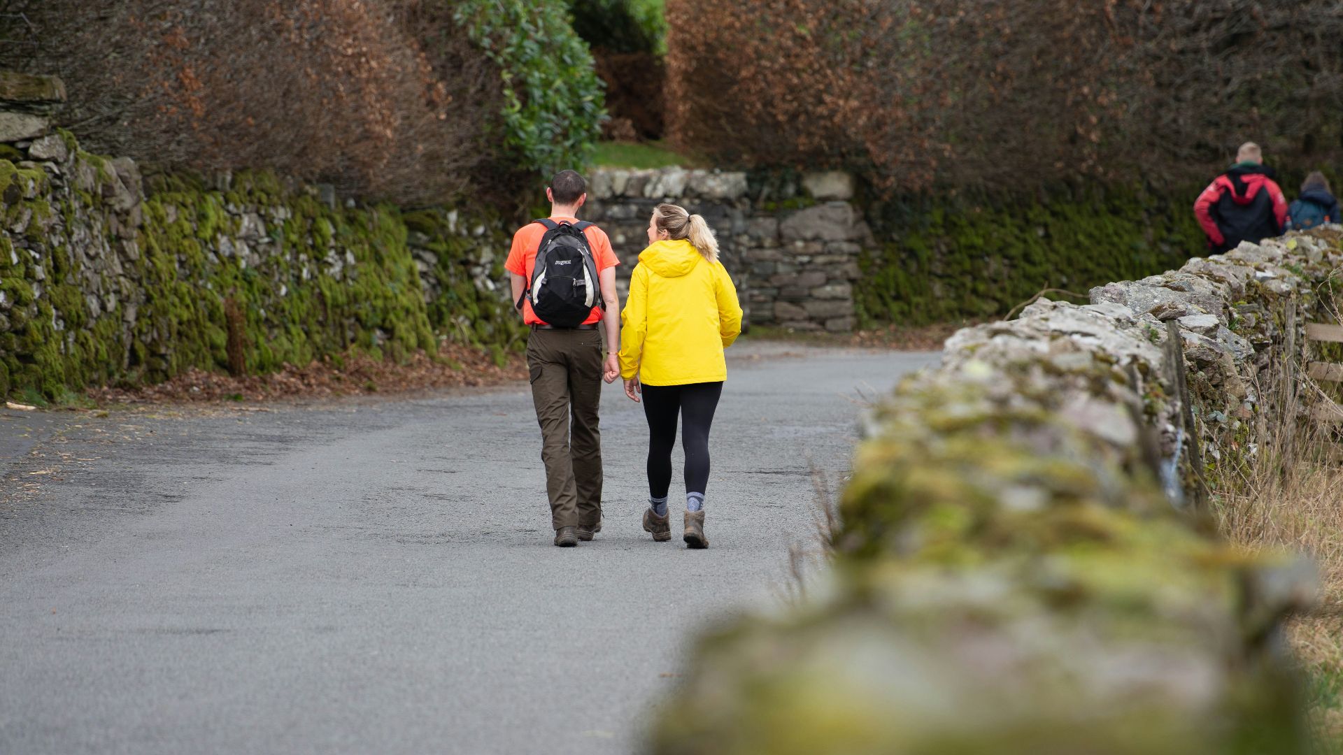 a couple of people walking down a road