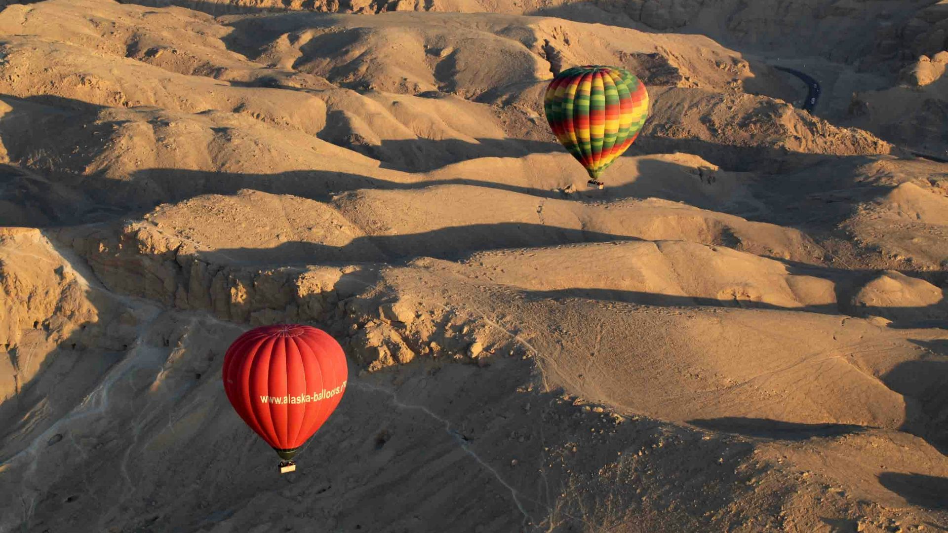 red yellow and green hot air balloon on brown sand