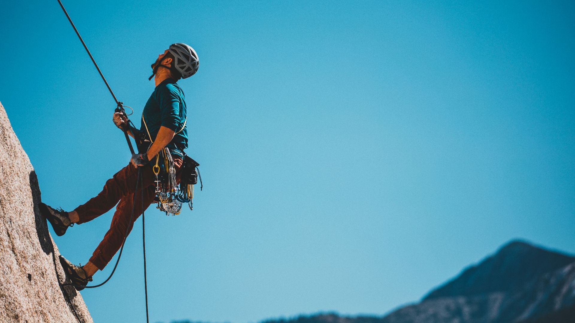 man in blue and orange jacket and black helmet riding on black and white ski lift