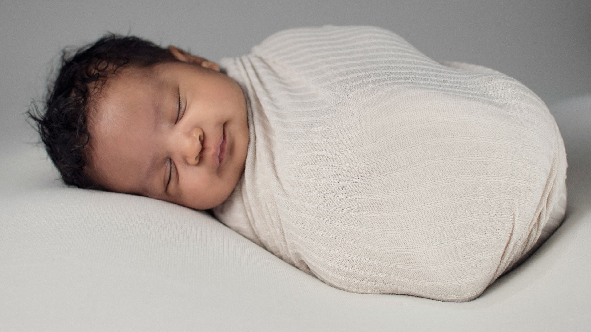 woman in white knit sweater lying on bed