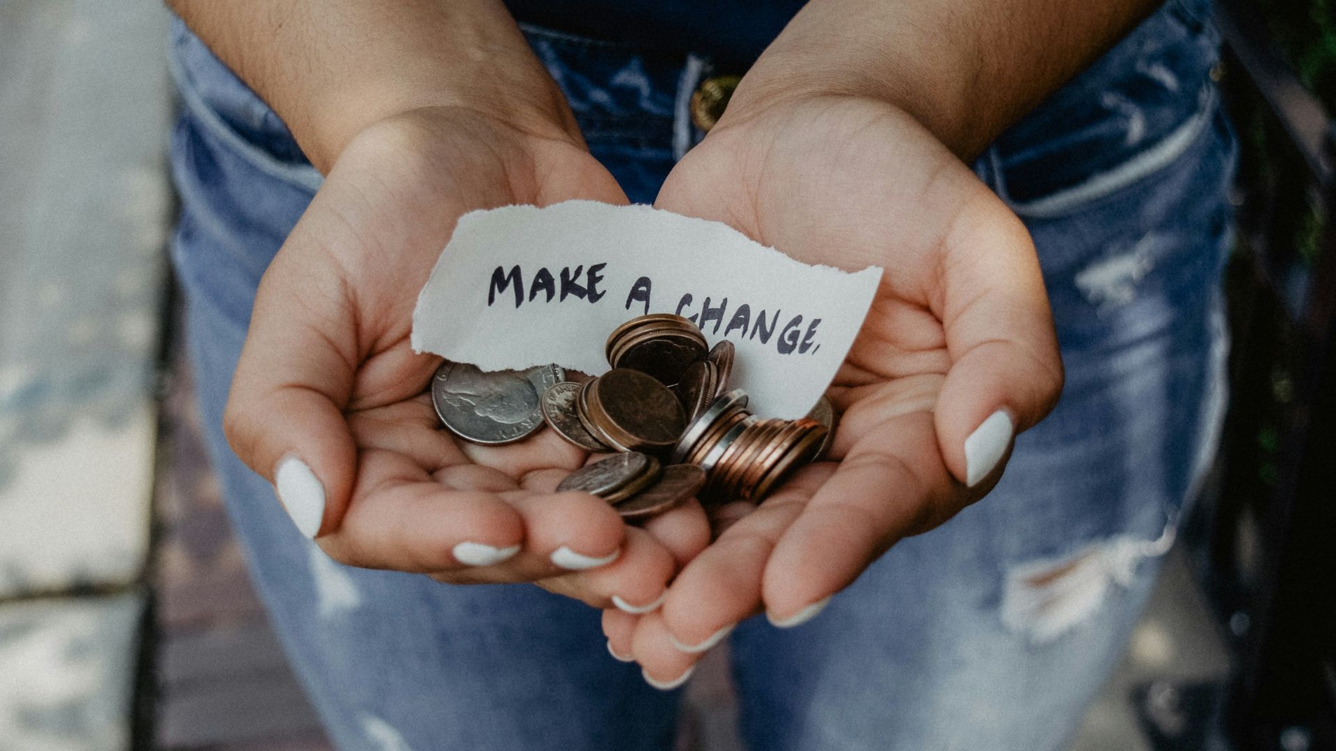 person showing both hands with make a change note and coins