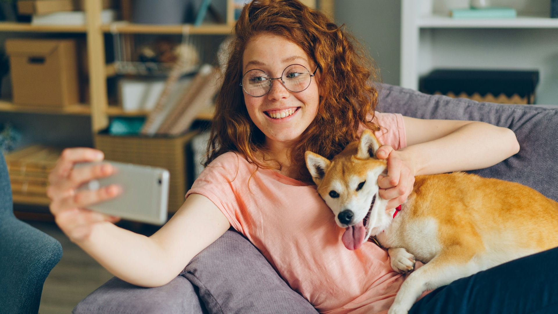 a woman sitting on a couch holding a dog