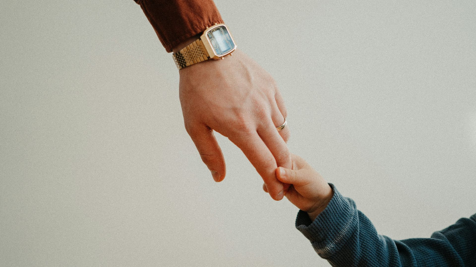 a person holding the hand of a child