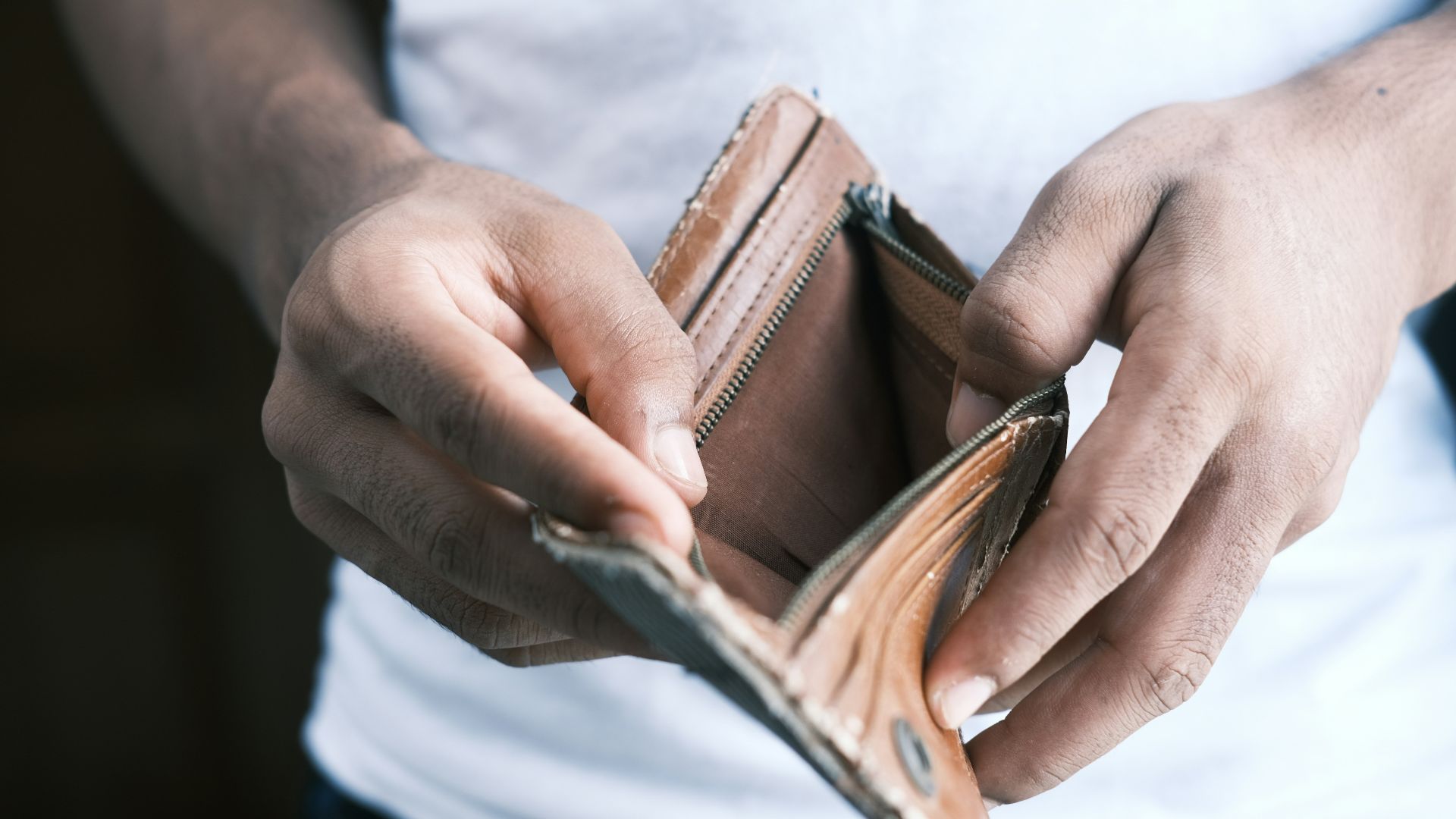 person holding brown leather bifold wallet