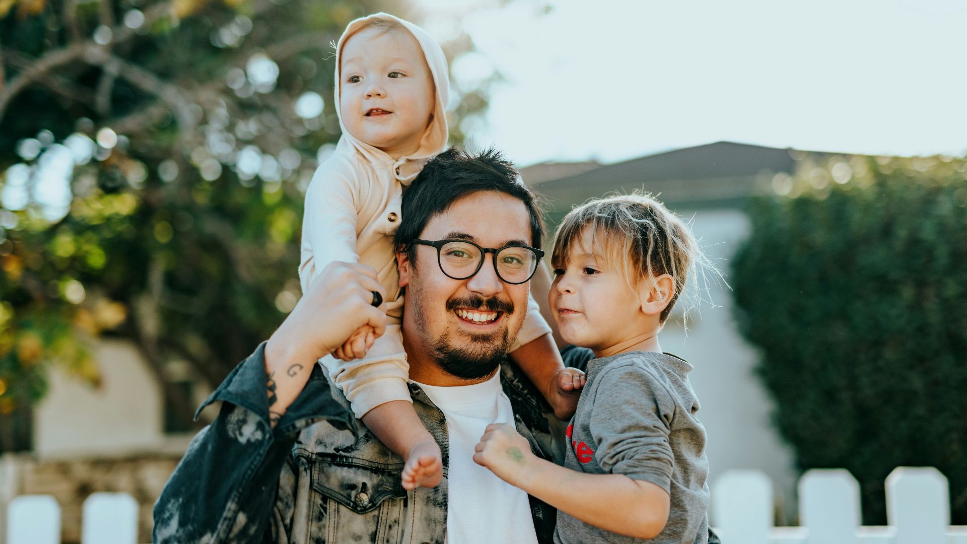 man in white shirt carrying girl in gray shirt