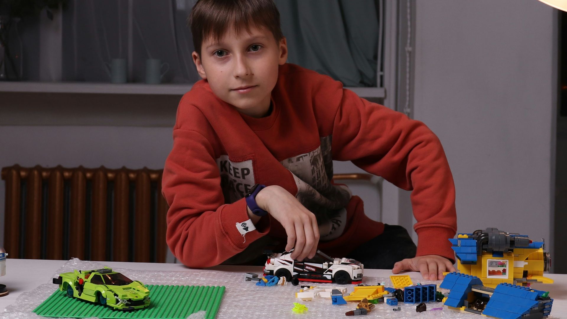 a young boy playing with a lego set on a table