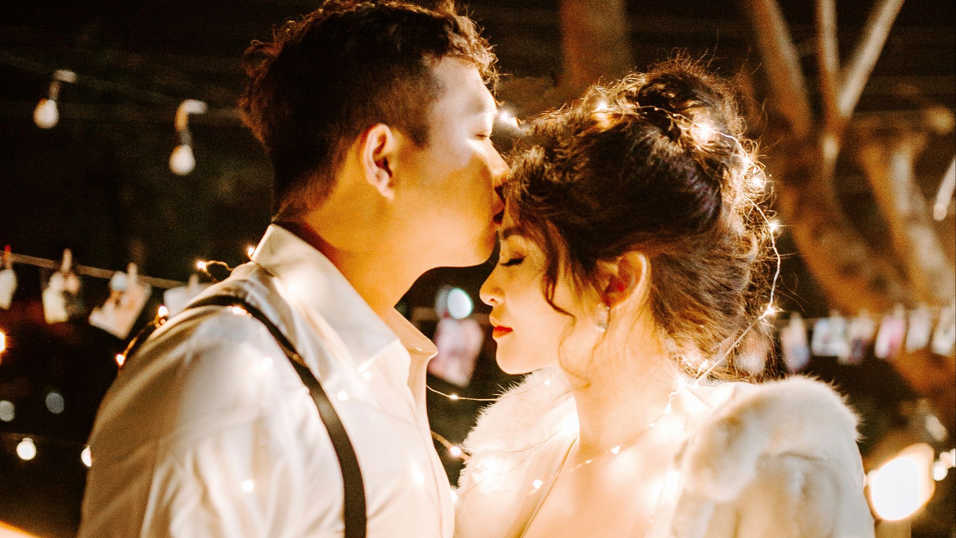 man kissing woman's forehead