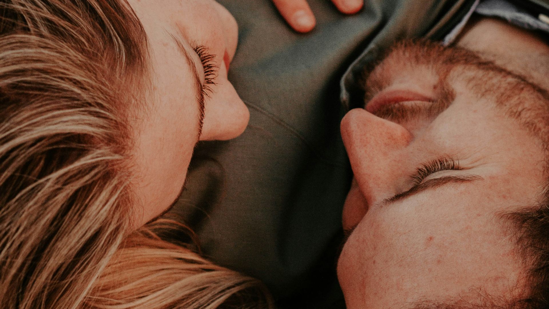 a woman stares into a man's eyes lovingly