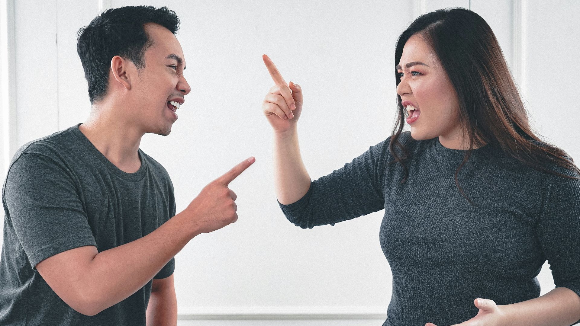 man in gray crew neck long sleeve shirt standing beside woman in black crew neck shirt