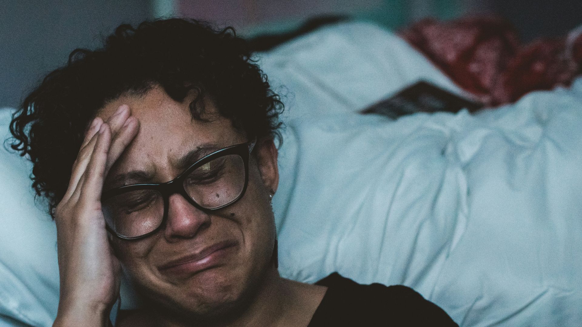 person crying beside bed