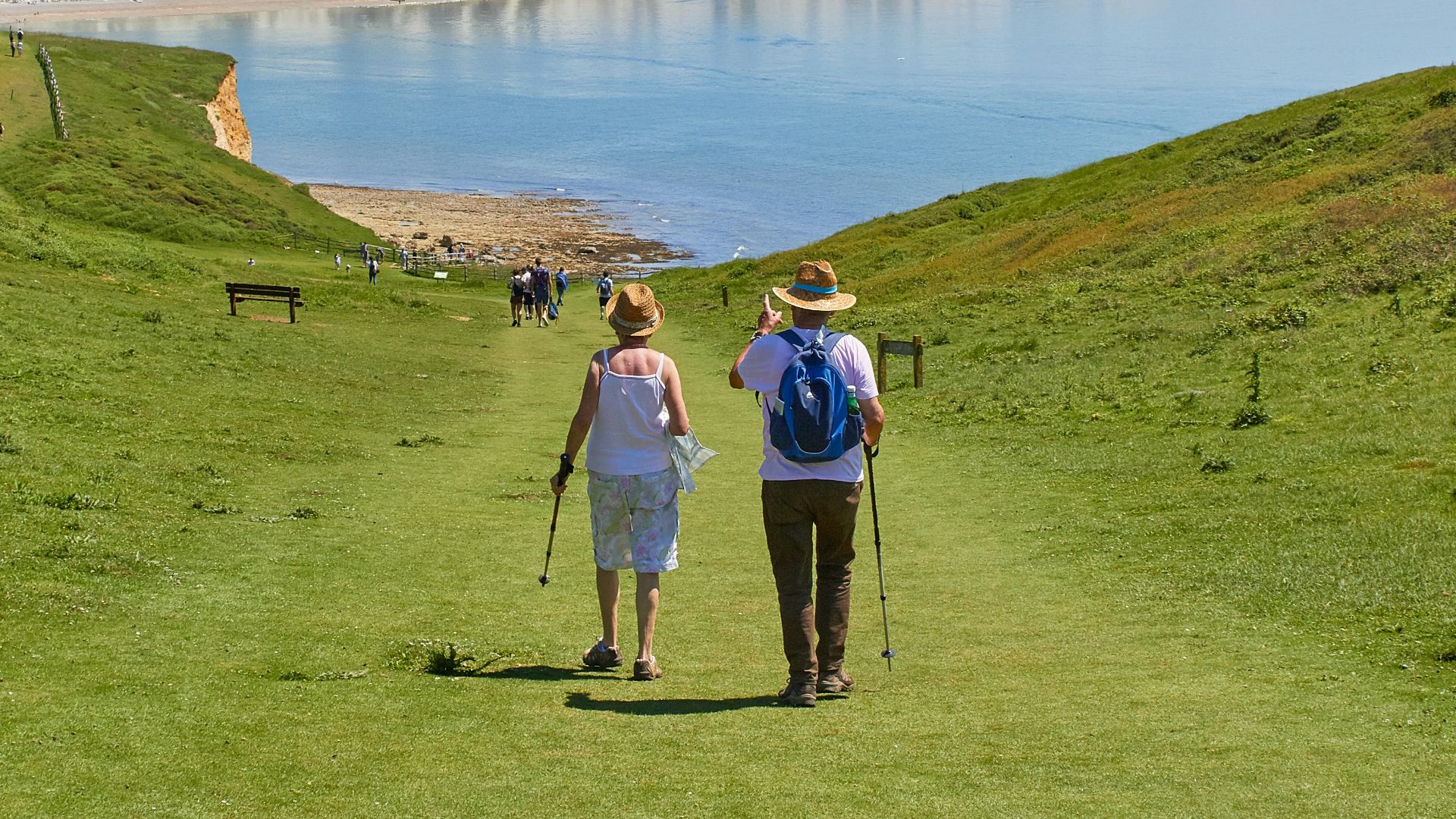 2 men standing on green grass field near body of water during daytime