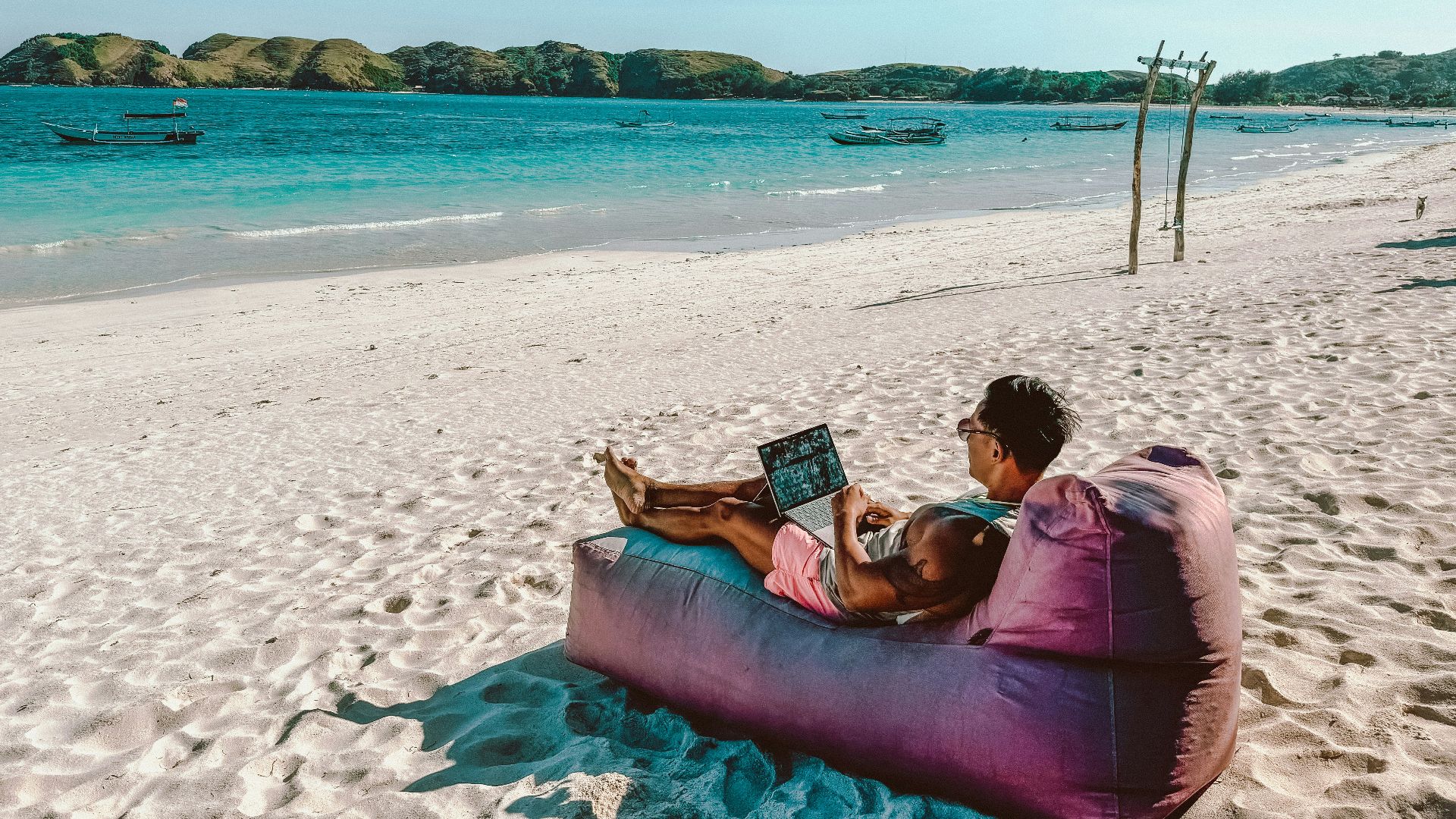 a man sitting on a bean bag on the beach