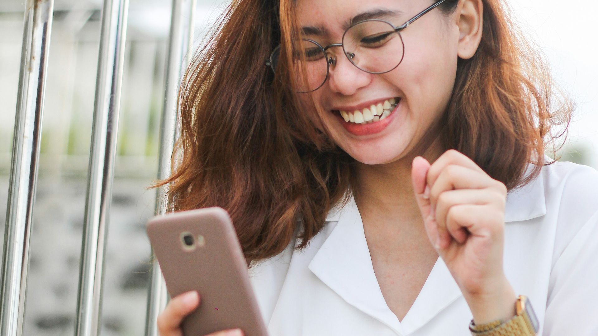 woman in white button up shirt holding silver iphone 6
