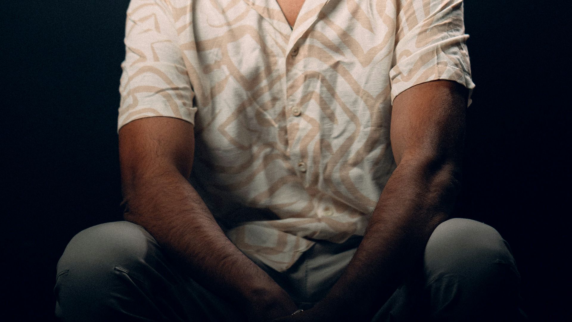 a man sitting on the ground with his eyes closed