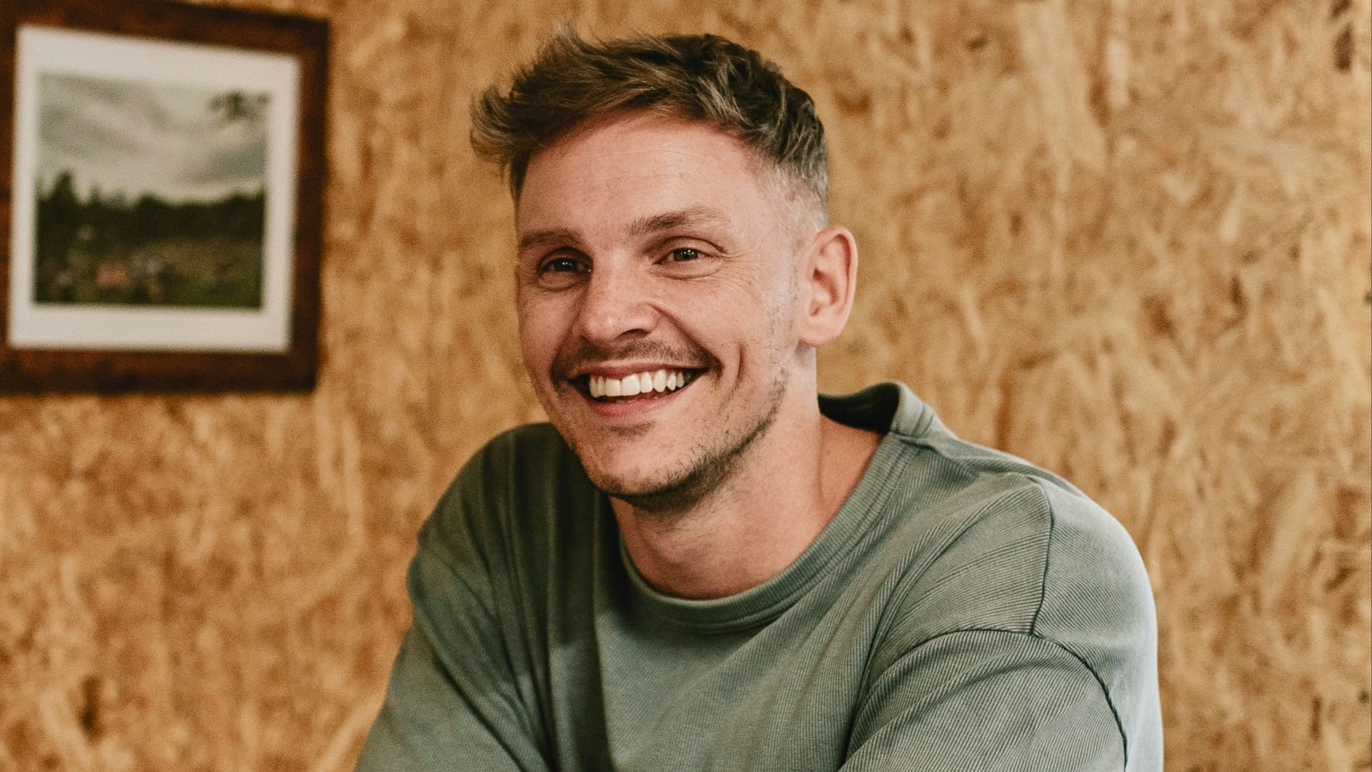 A man sitting at a table with a pool cue in his hand