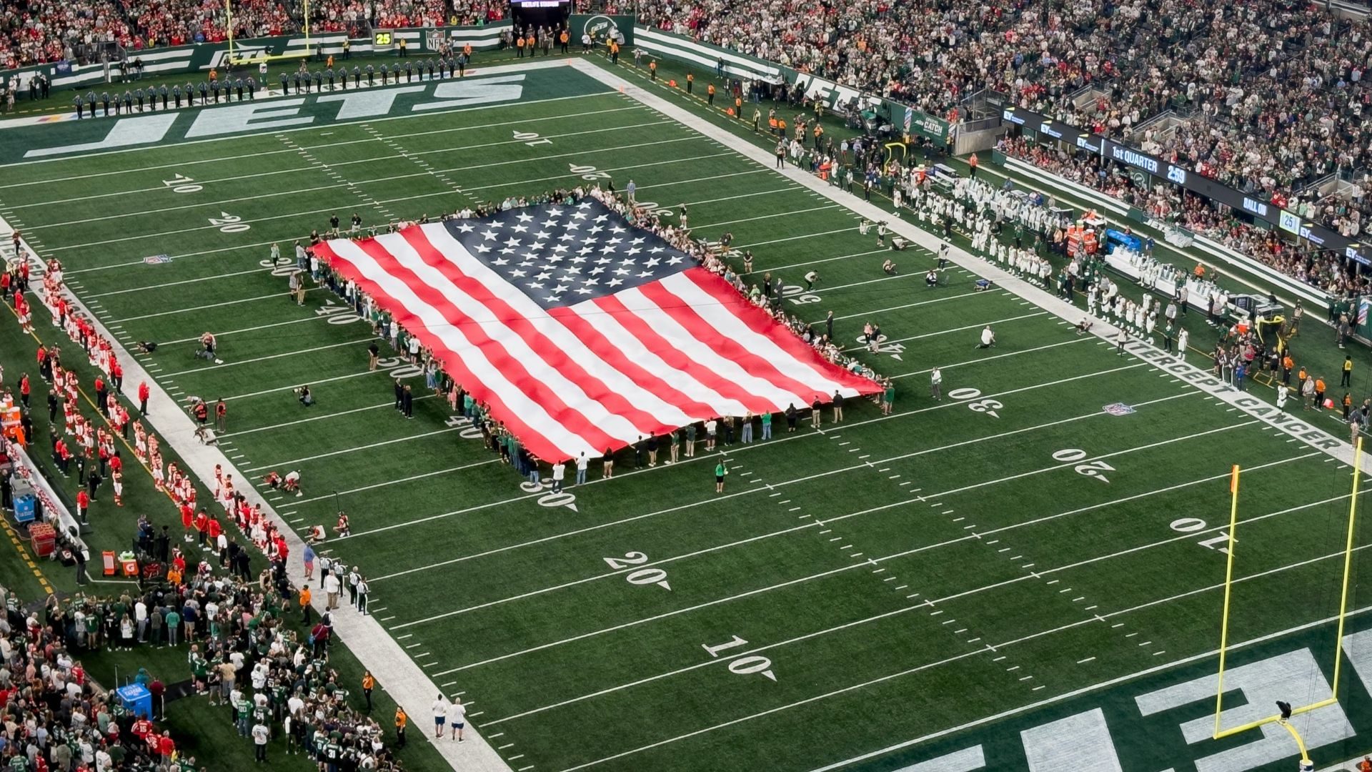 a football field with a large american flag on it