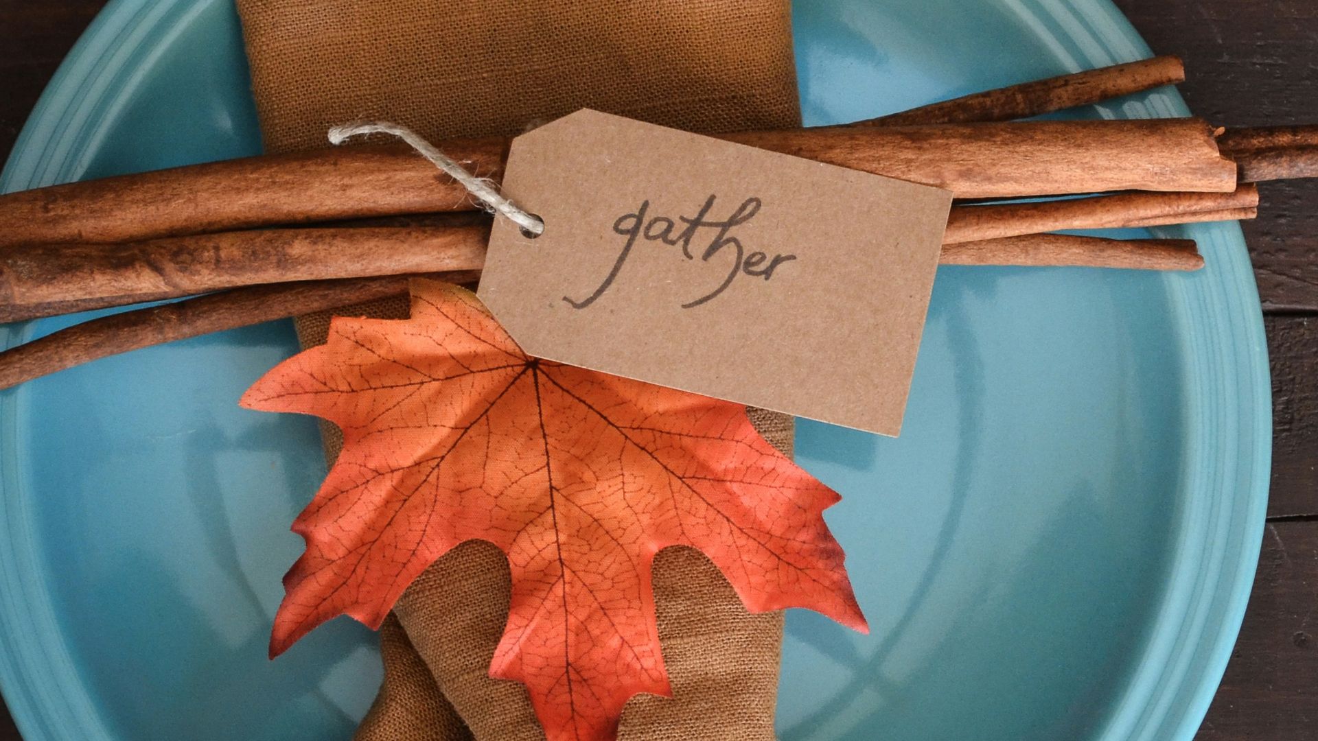 a blue plate topped with an orange and brown leaf