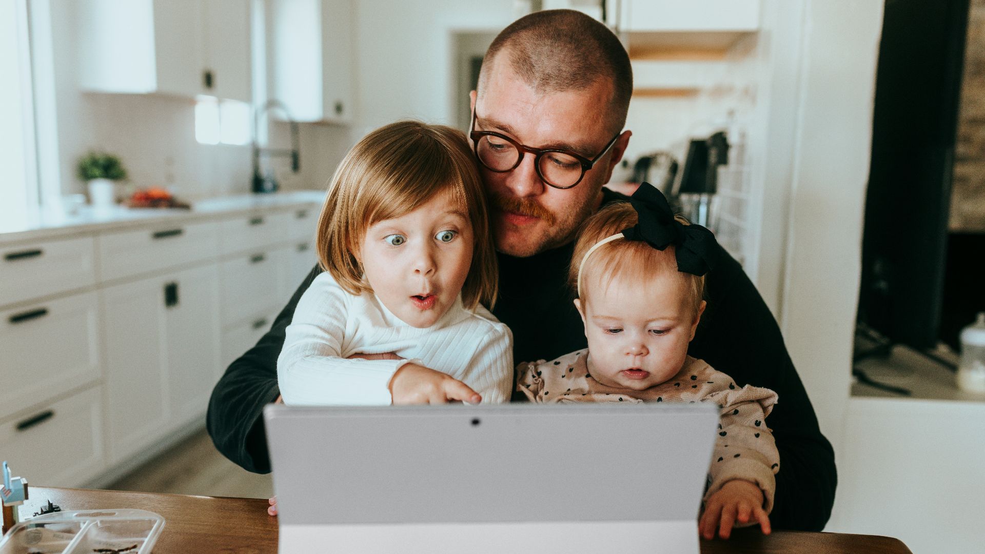 a man and two children looking at a laptop
