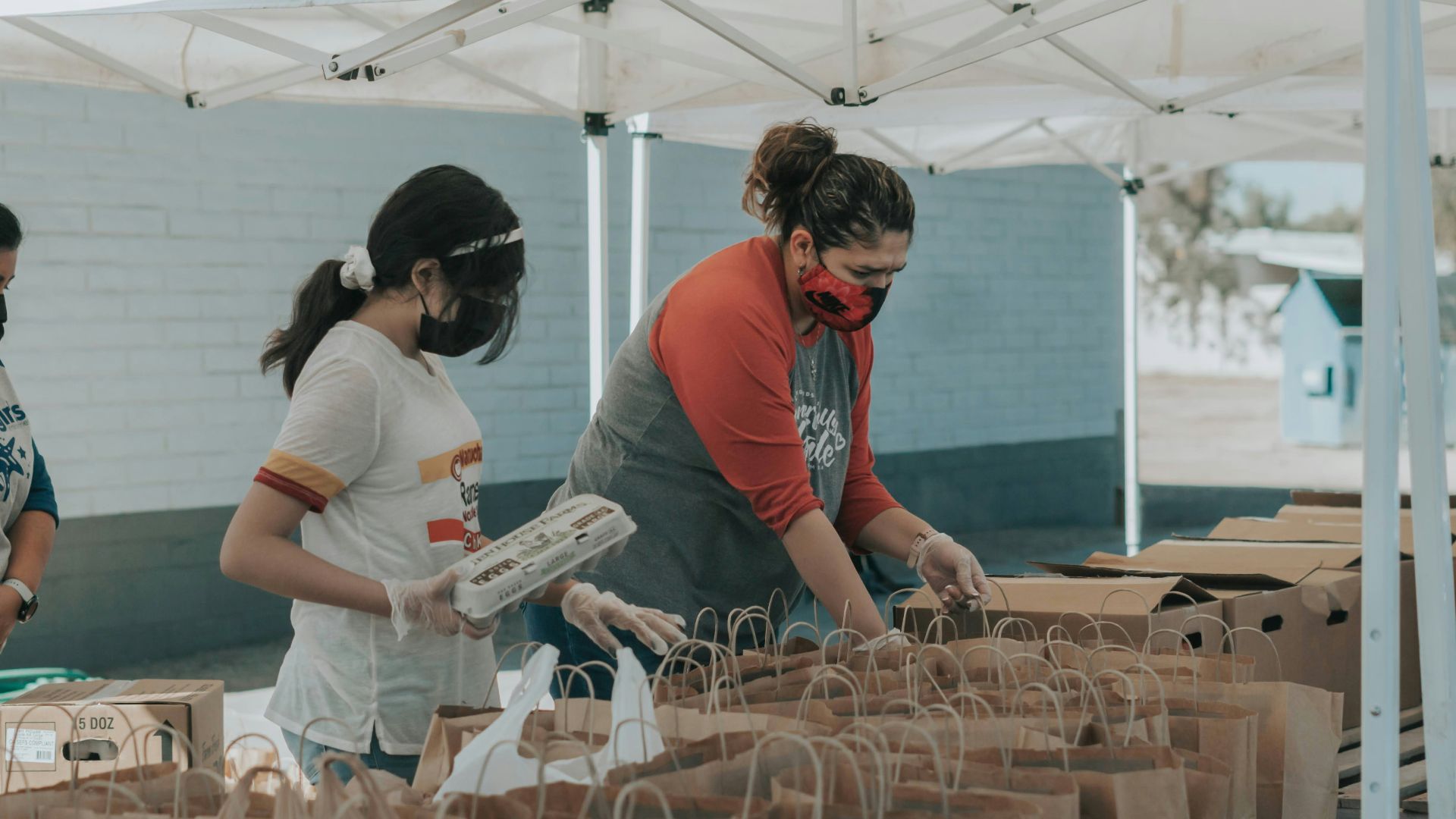 man in red t-shirt holding white plastic bottle