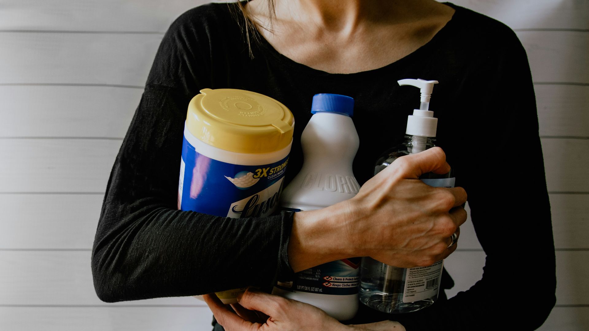 woman in black long sleeve shirt holding white and yellow plastic bottle