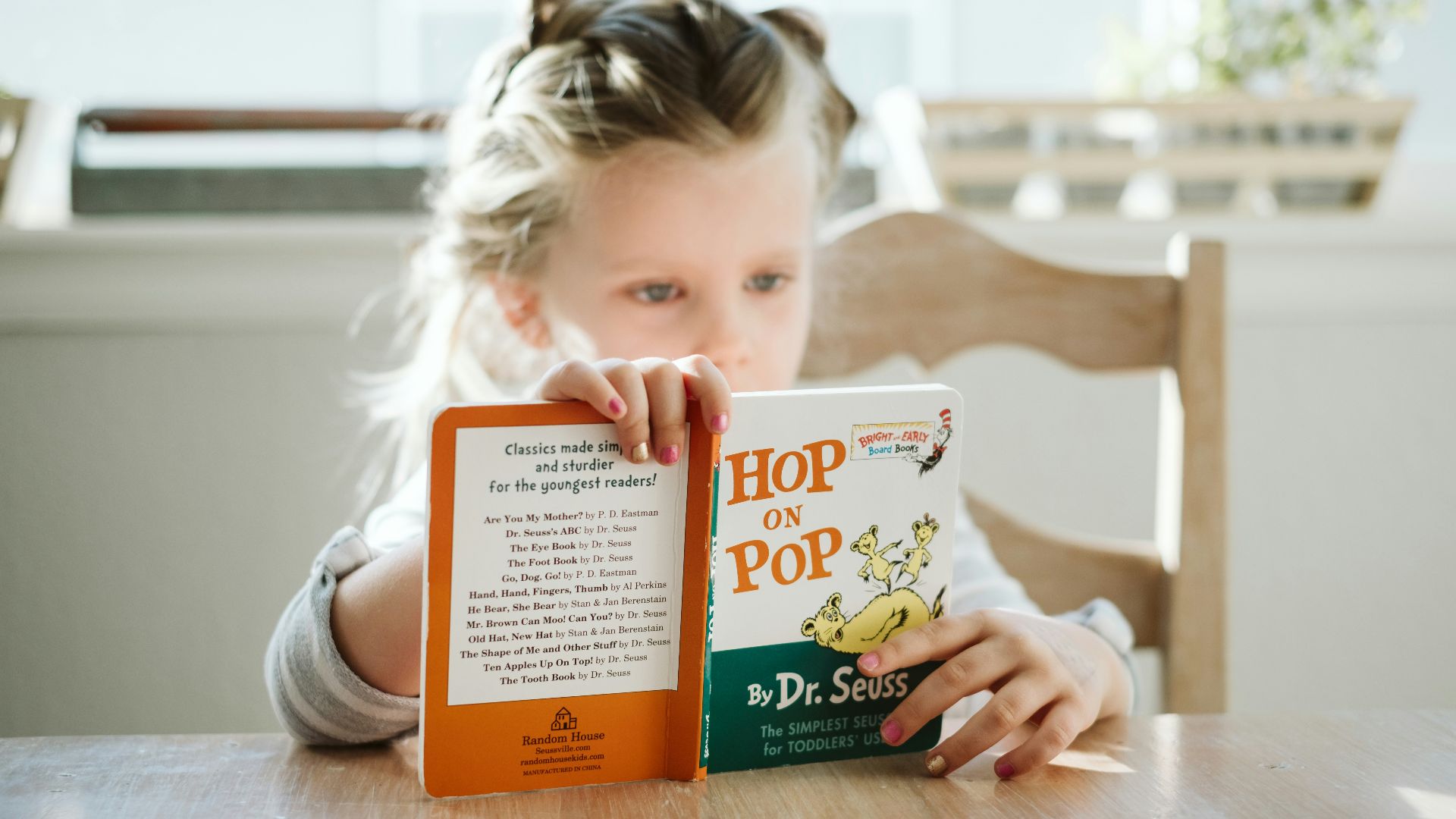girl sitting while reading book
