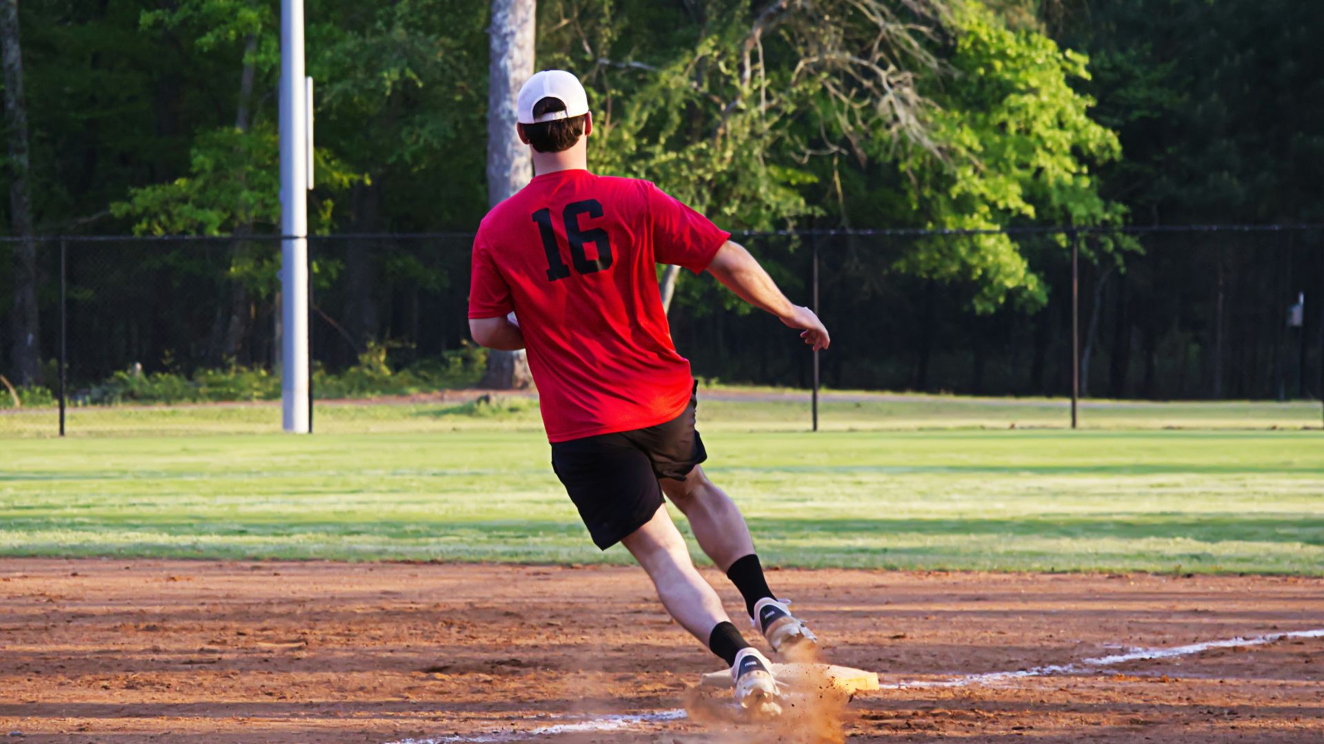 A baseball player runs towards a base.