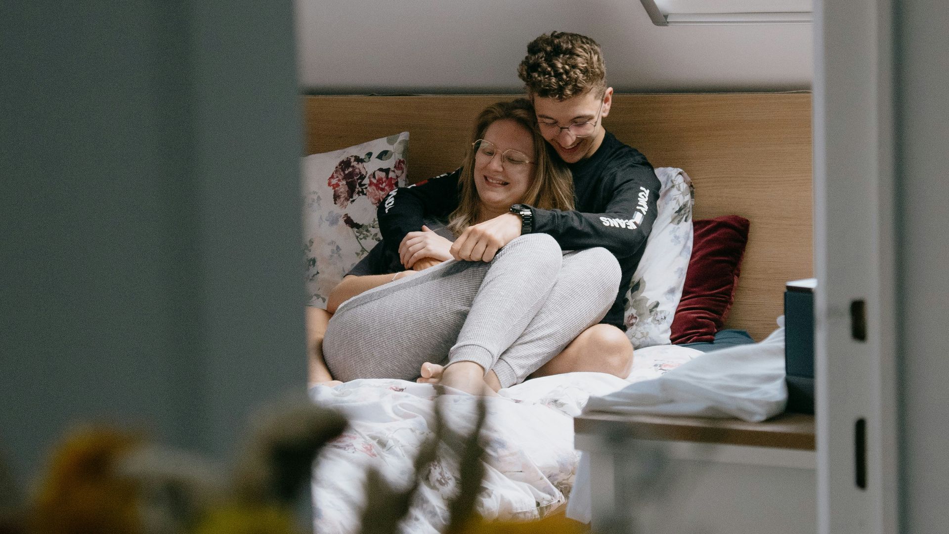 woman in white long sleeve shirt sitting on bed