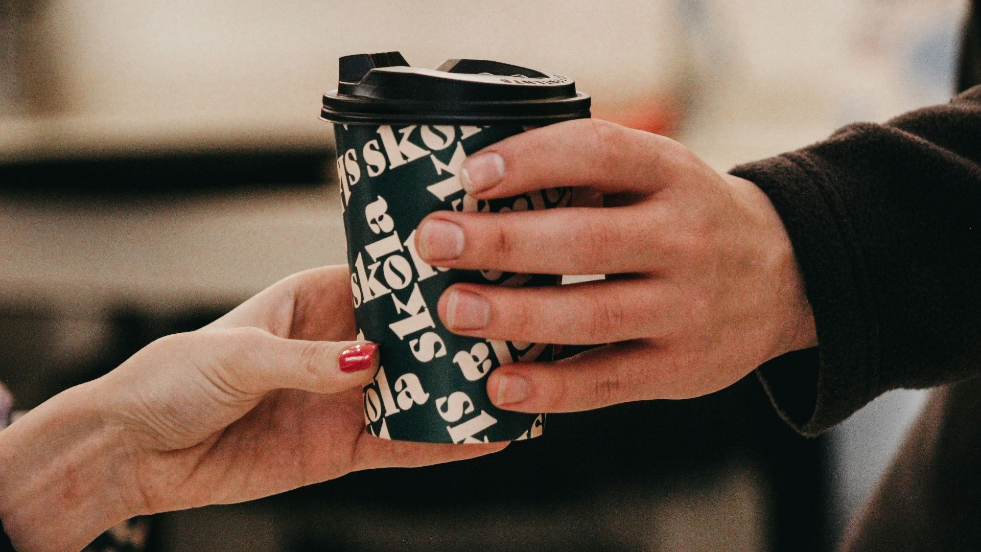 a person handing another person a cup of coffee