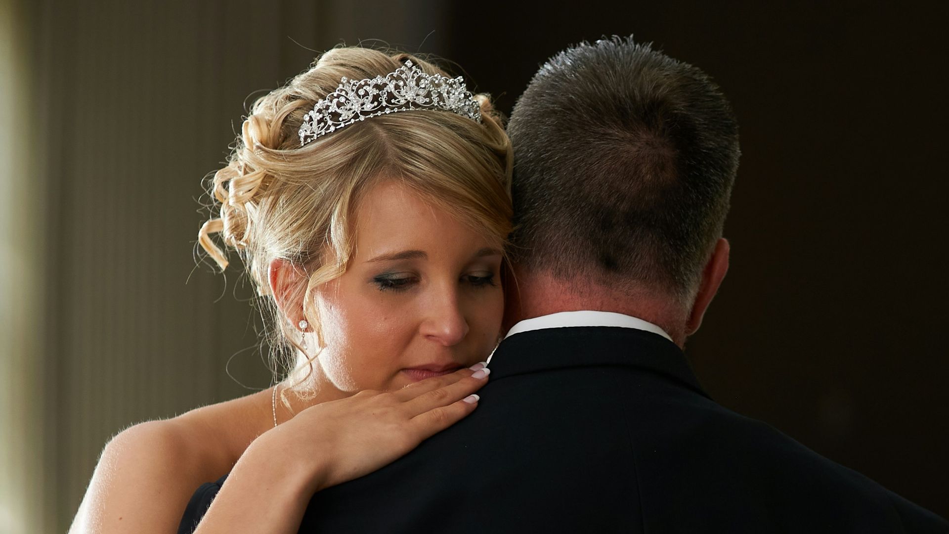 man in black suit kissing woman in white wedding dress