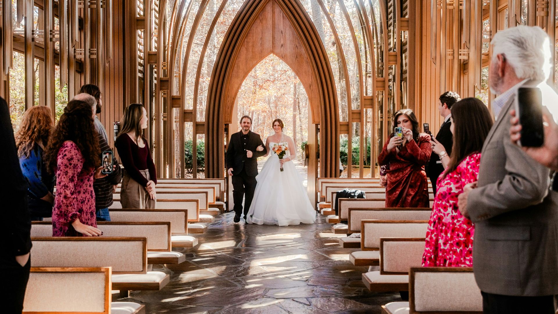 a bride and groom walking down the aisle of a church