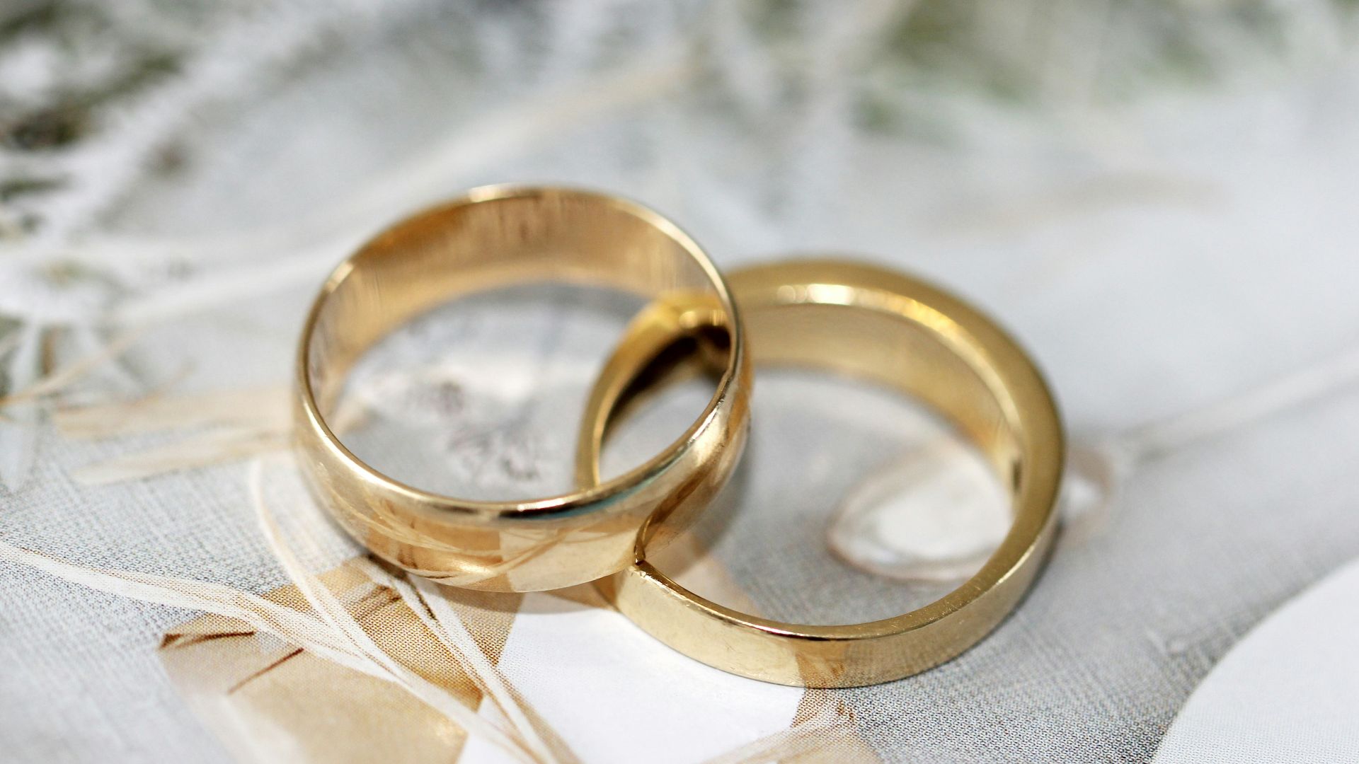 gold wedding band on white textile