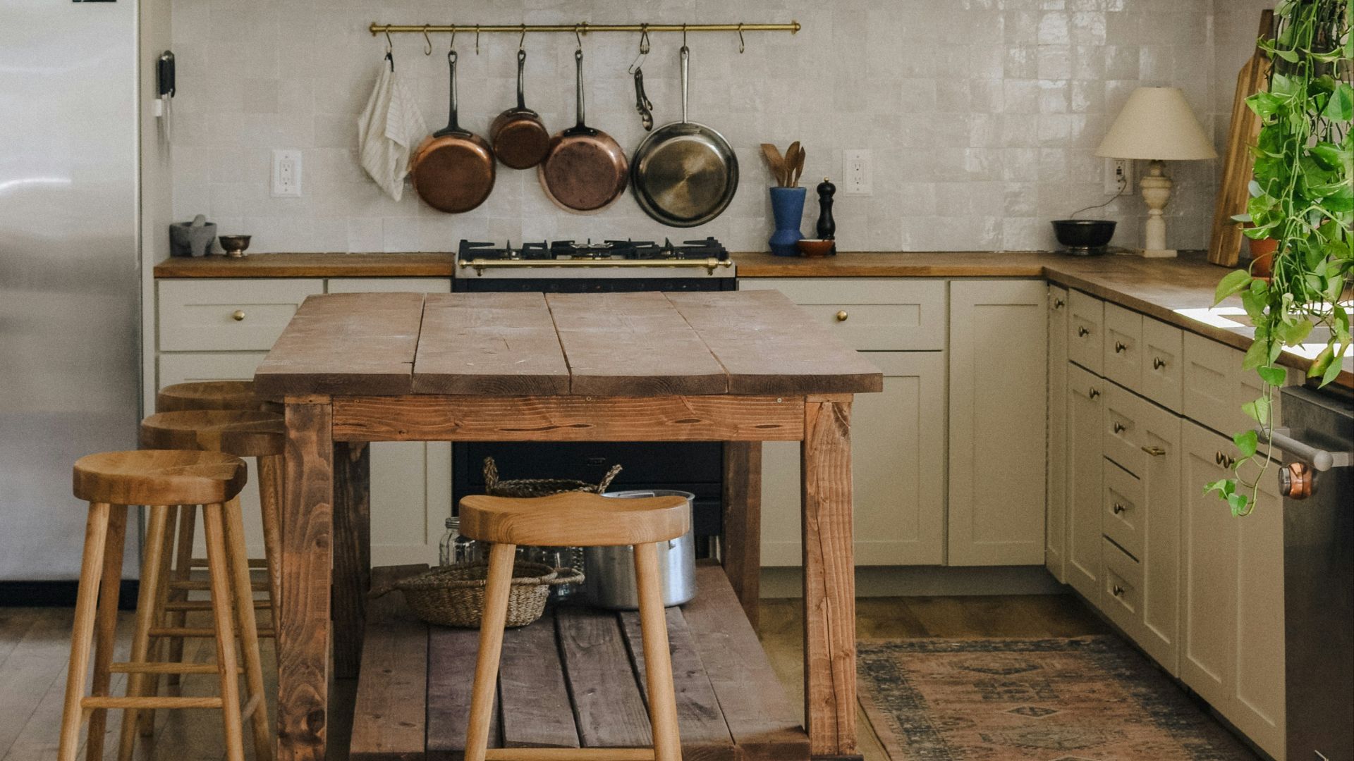 brown wooden seat beside white wooden kitchen cabinet