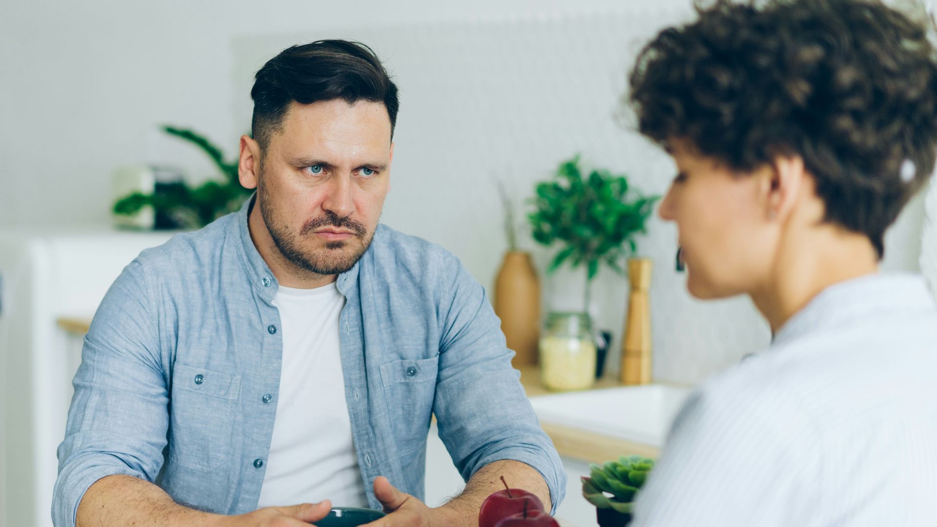 a man sitting at a table talking to a woman