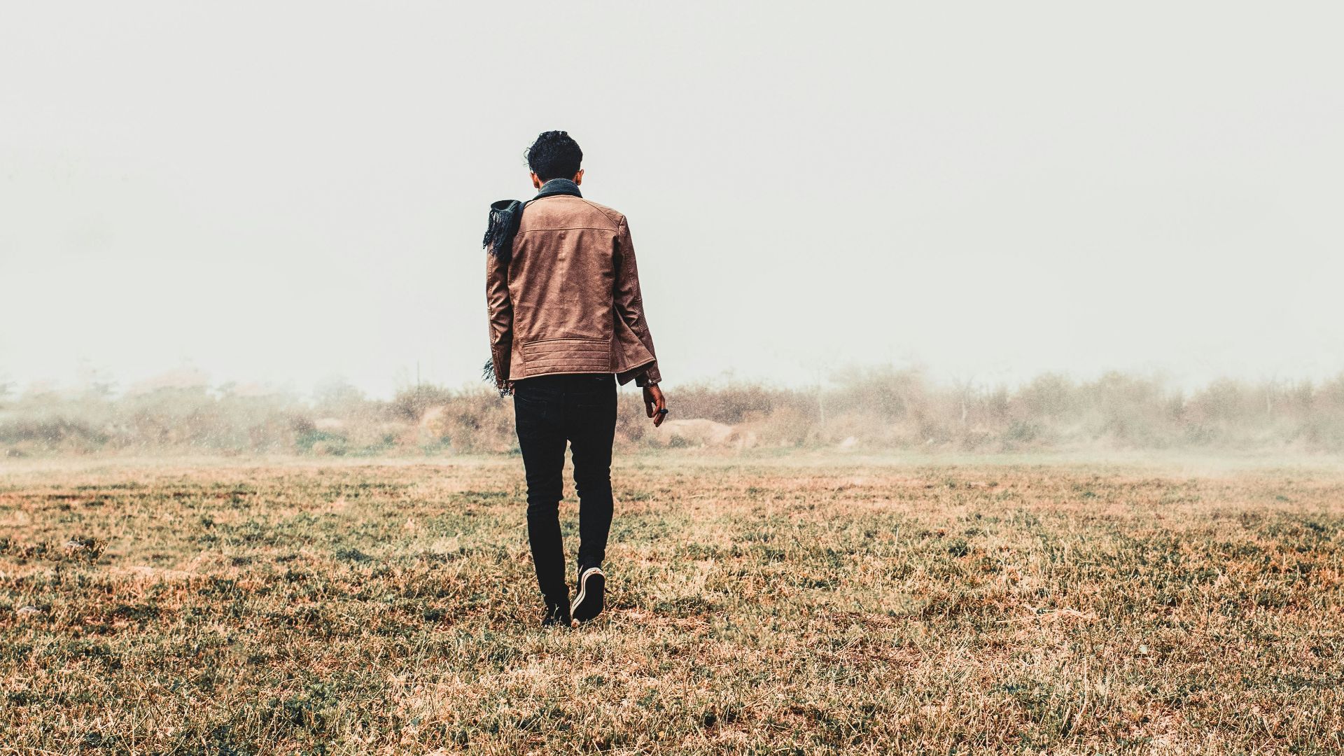 a man standing in a field with his back to the camera