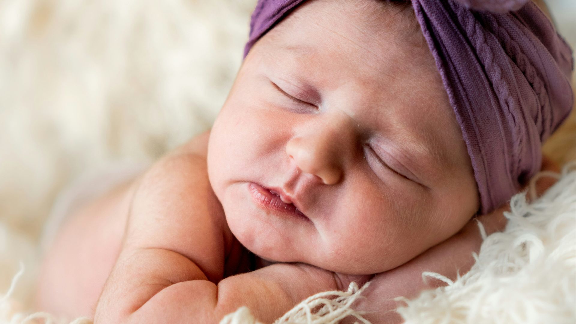 girl in white fur coat lying on white fur textile