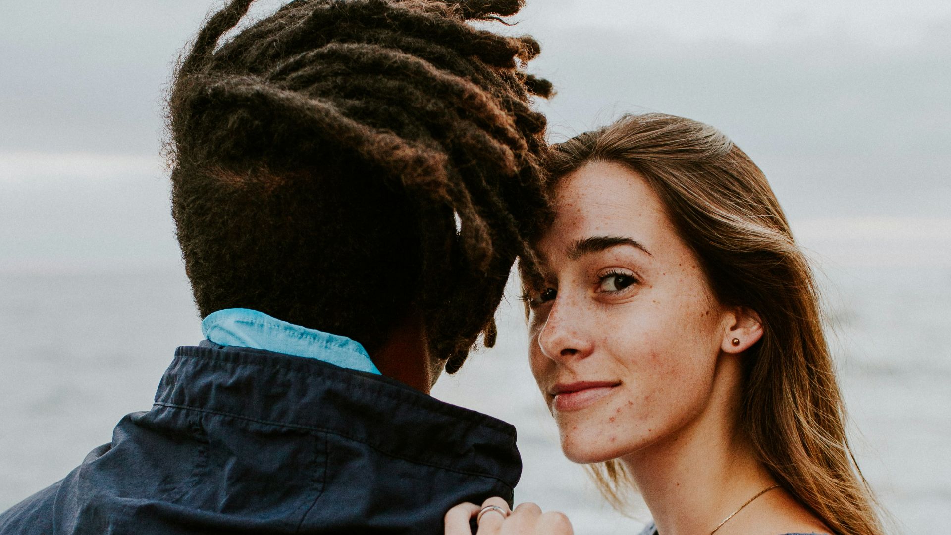 woman in blue long sleeve shirt beside woman in gray long sleeve shirt
