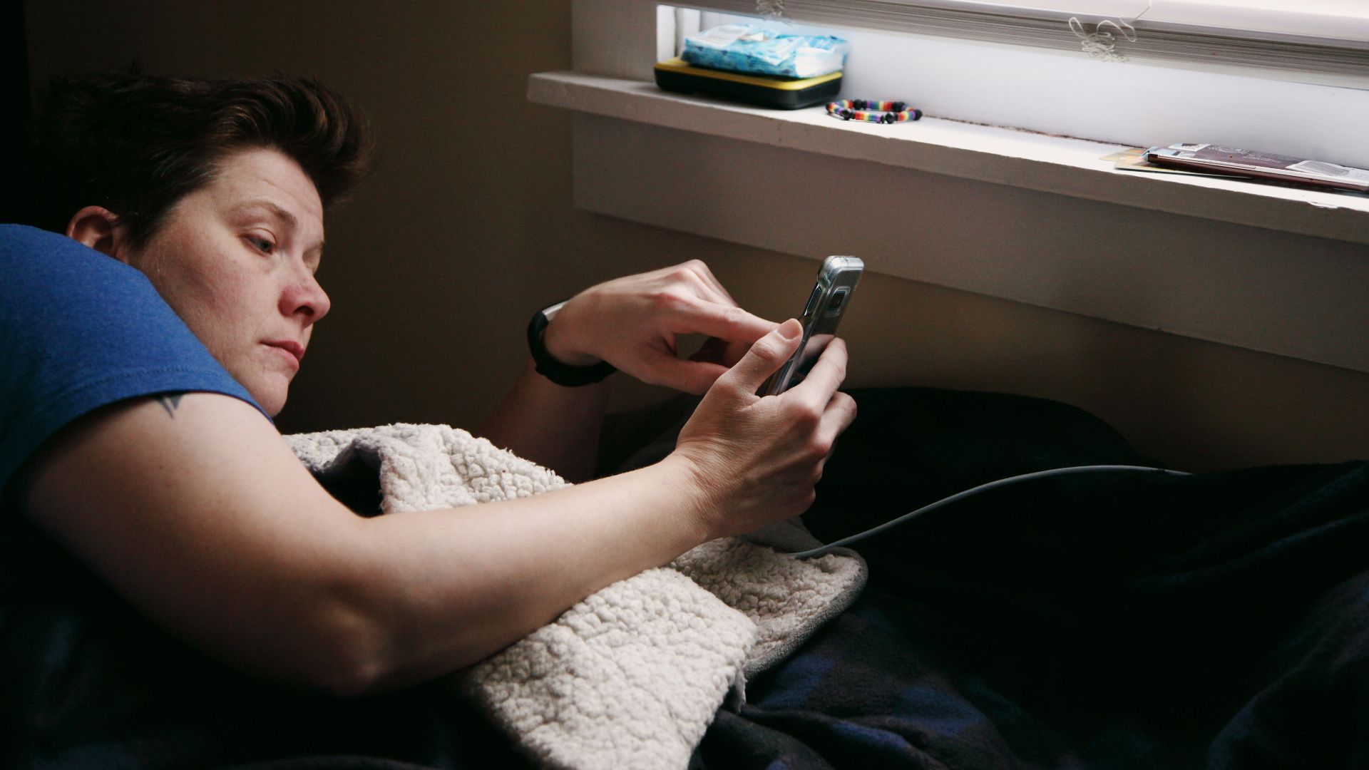 man in black shirt holding black smartphone