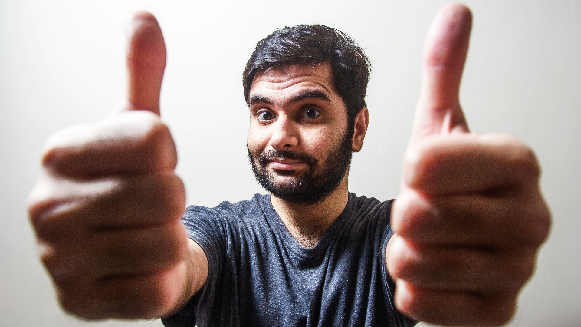 man in gray crew neck shirt making thumbs up