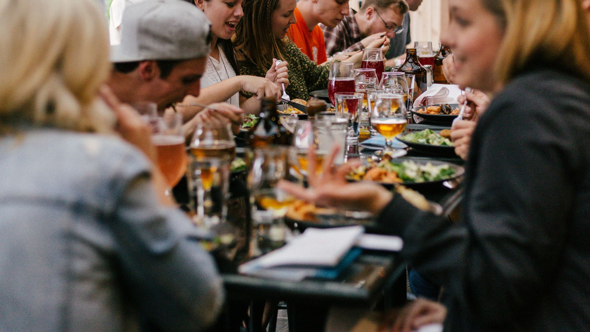 people sitting in front of table talking and eating