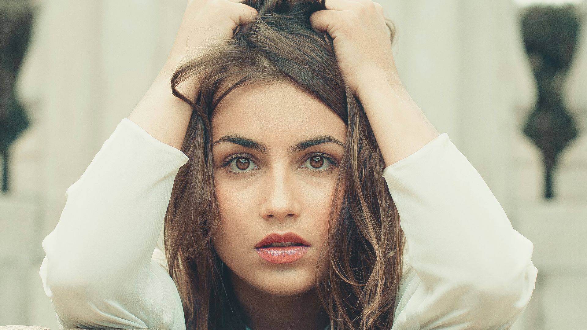 woman in white long sleeve shirt lying on bed