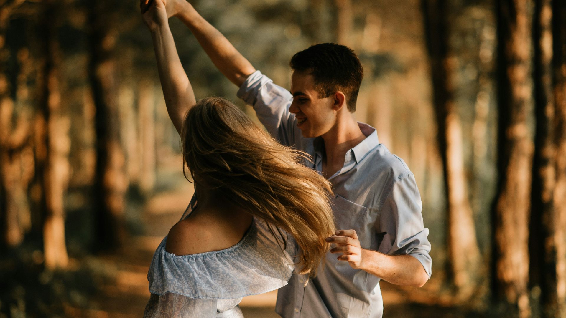 man and woman dancing at center of trees