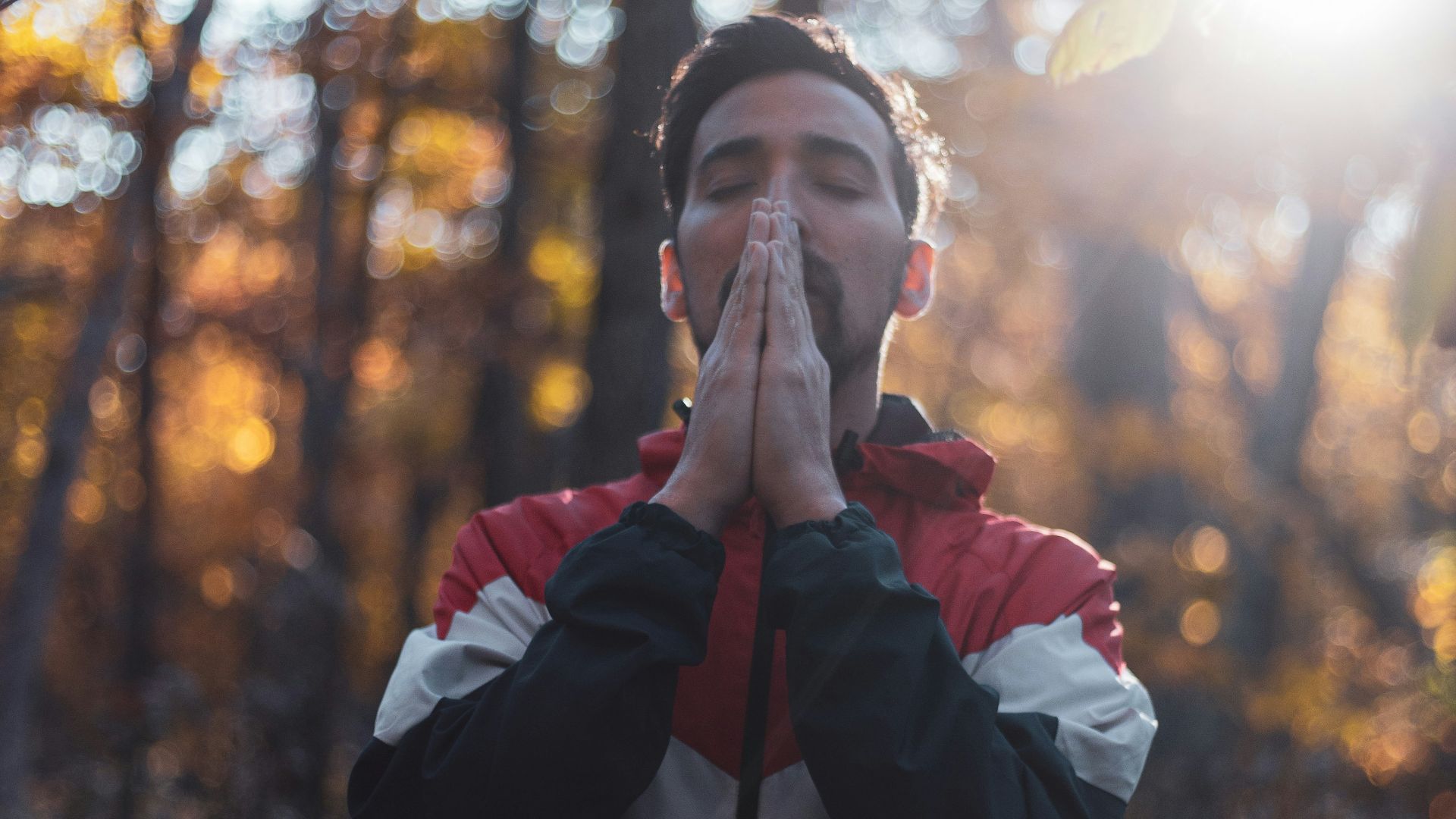 shallow focus photo of man in black, white, and red full-zip hoodie