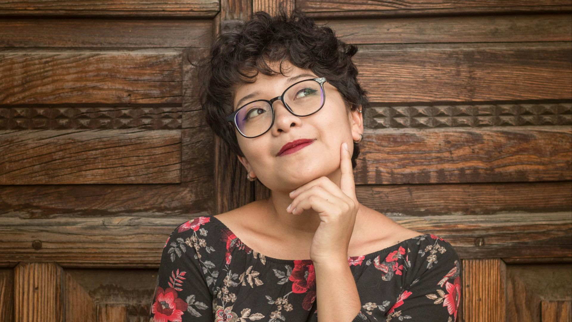 woman leaning against door while holding her cheek