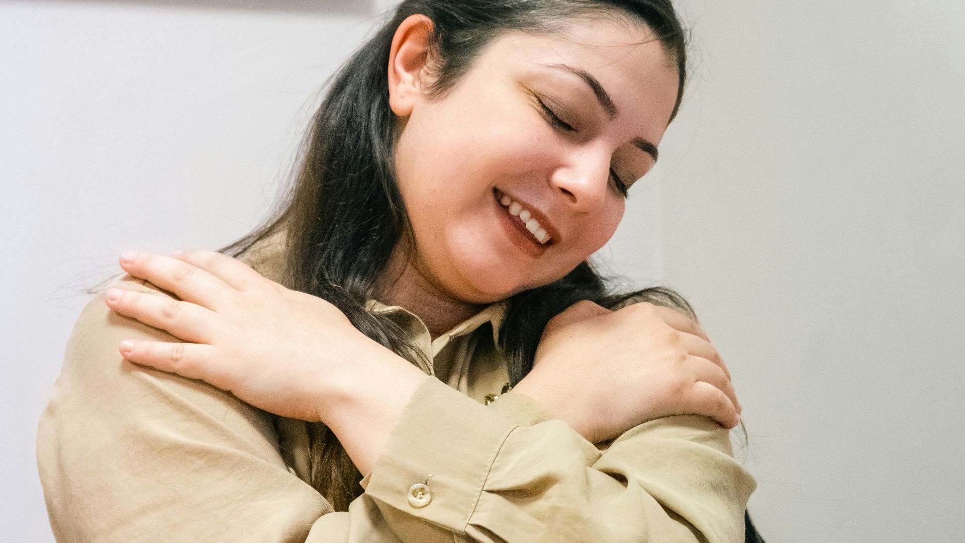 a woman sitting at a desk with her arms crossed