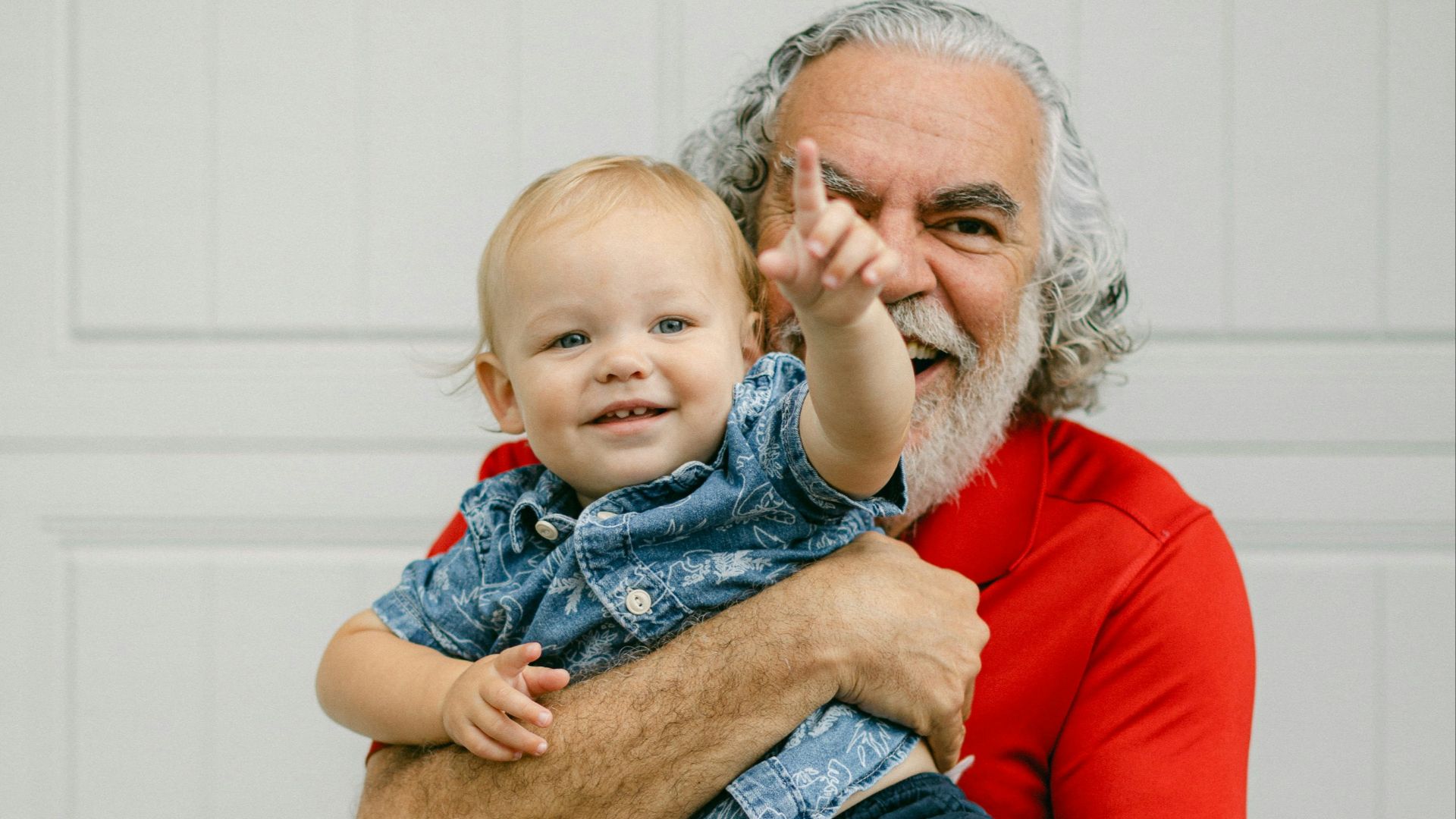 a man holding a baby in front of a garage door