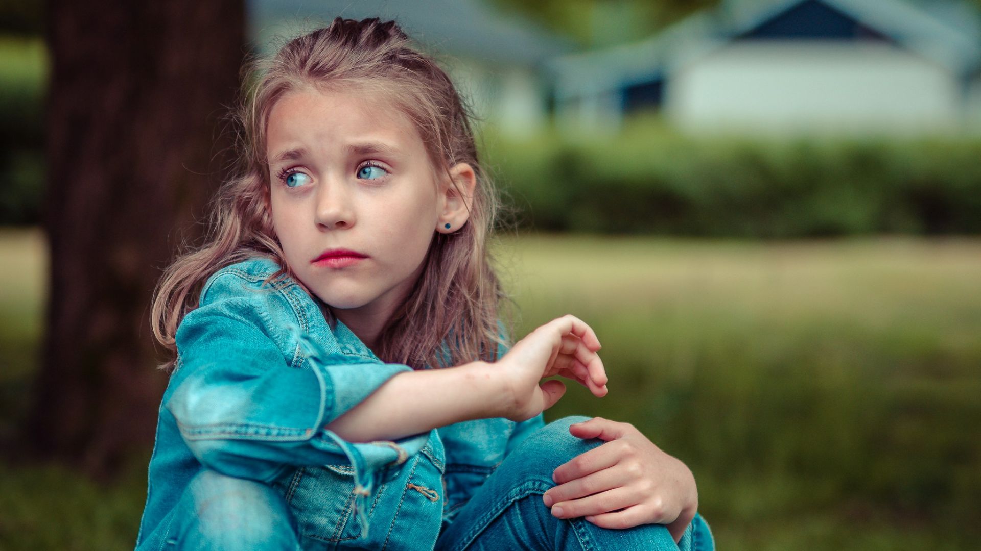 selective focus photography of girl sitting near tree